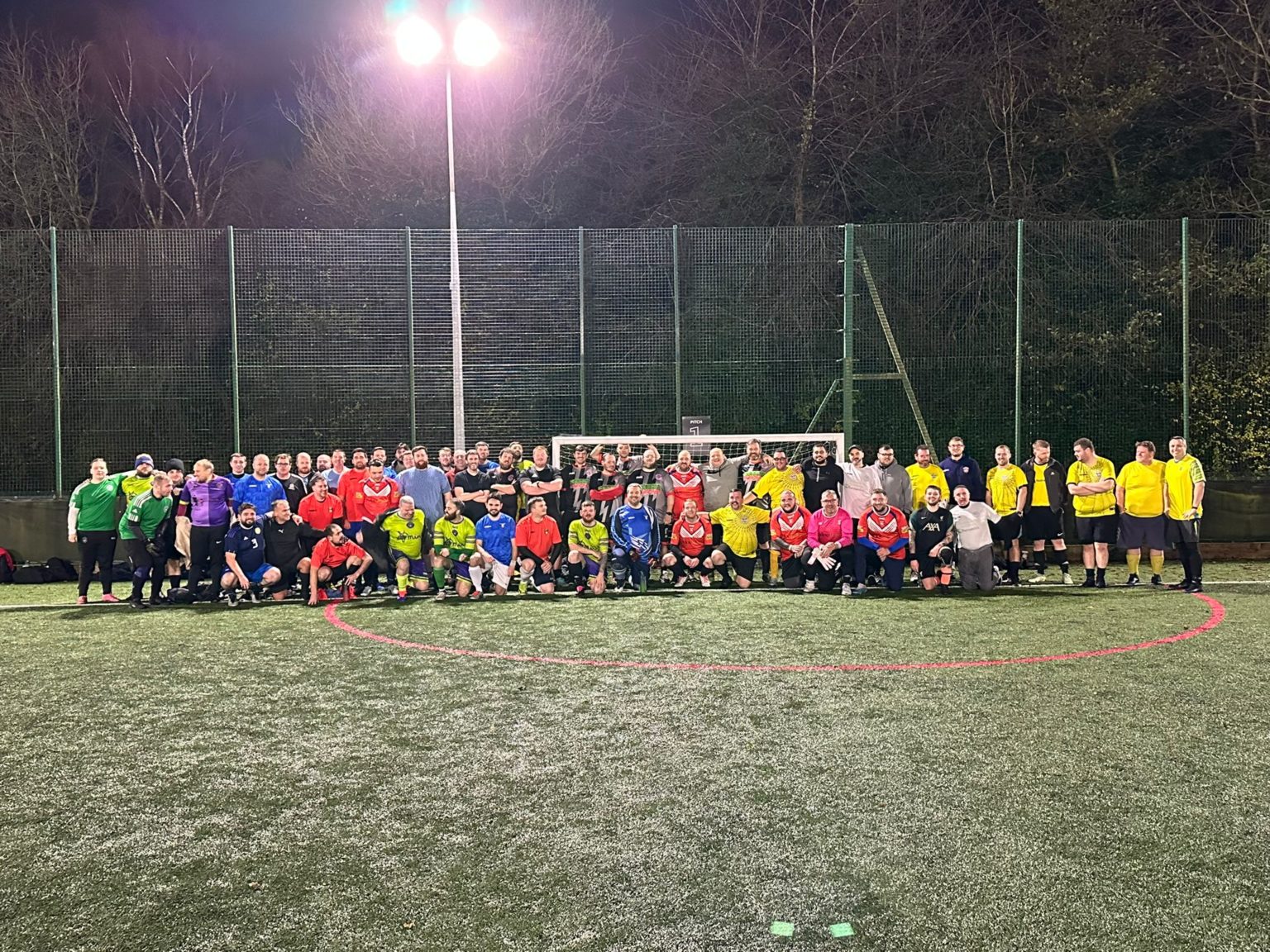 All the MAN v FAT St Helens players lined up together on the pitch under the floodlights